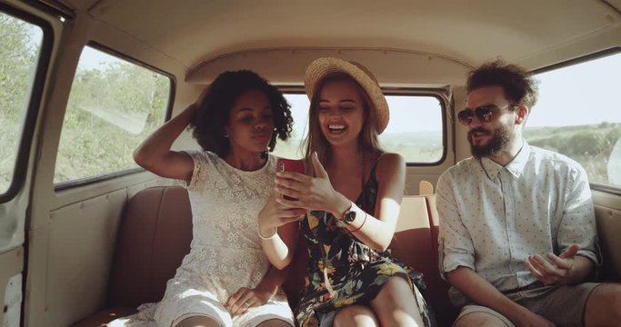 Retro stylish friends , two perfect girls with a beautiful smile and one man on the way in the retro bus looking through the phone , they have a happy faces. slow motions . 4k
