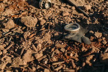 Torn respirator mask and used cartridges from the weapons. 