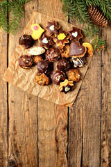 View from above of christmas sweets with different types of candy on baking paper on rustic wooden table