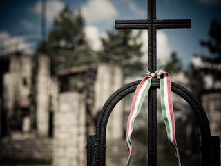 hungarian flag colored band tied to a religious christian cross in front of a church building at Budapest, Hungary