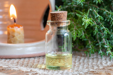 A bottle of thyme essential oil with fresh thyme