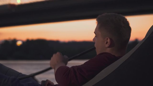 Handsome guy smokes hookah outdoors