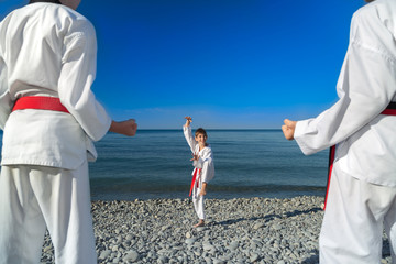 Тренировка троих детей на пляже, на море: тхэквондо, спорт, трио - obrazy, fototapety, plakaty