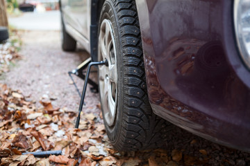 Lifting screw jack, lug wrench for replacing summer tire for winter studded. Autumn season