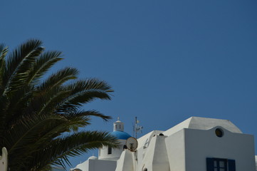 Fototapeta na wymiar View Of Blue Vaulted Roofs In Oia Town Santorini Island. Architecture, Landscapes, Travel, Cruises. July 7, 2018. Santorini Island, Thera. Greece.