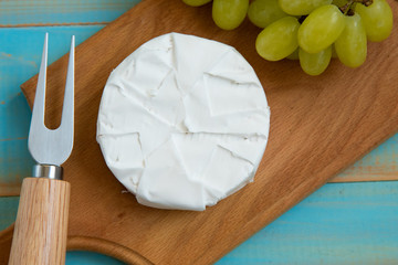 cheese camembert with a fork for cheese and grape