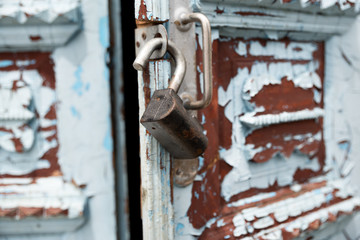 Close-up keyholes with curtains and a handle on the blue many times painted cracked double-barreled wooden vintage door of the last century with a post slit.