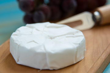cheese camembert with a fork for cheese and grape