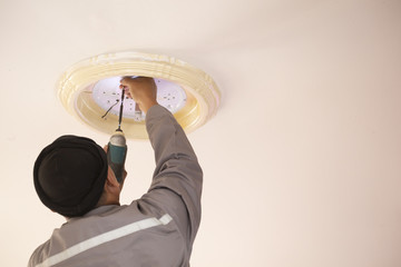 Electric hands changing ceiling lamp repair. Repair and service concept.