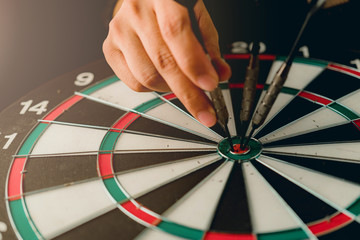 red arrow dart board with hand hold closeup business strategy  concept aim for goal target with...
