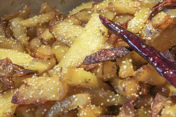 Fried potato pieces with fried red chilly