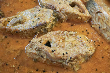 Hilsa fish pieces on a plate.