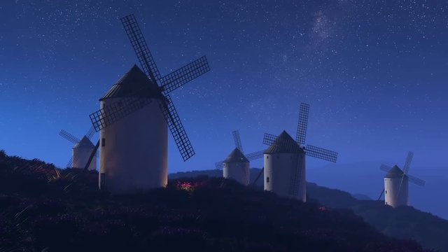 Multiple old, vintage, Spanish windmills rotating slowly at night. 4K HD