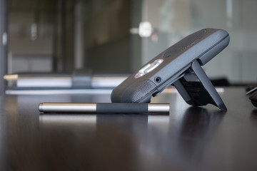 Wireless Communication Device, voice over internet phone on clean, dark brown office desk, stylus...