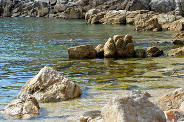 Beautiful wild beach in Greece with big rocks, beautiful sand and crystal clear water