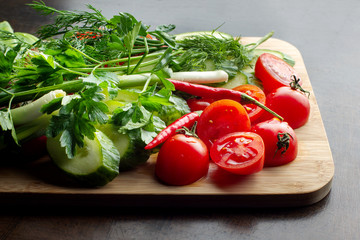Wooden plank with vegetables for a vegetarian salad.