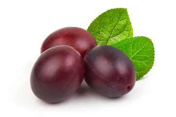 Fresh juicy ripe plums with leaves isolated on white background.