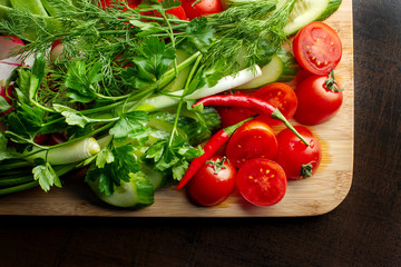Wooden plank with vegetables for a vegetarian salad.
