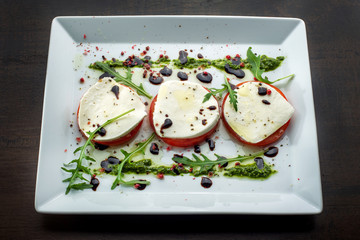 Tomato and mozzarella with basil leaves.