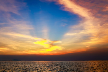 Vivid twilight sunset sky and motion blur of the sea under with long exposure effect.Beautiful golden sunset in the sea with saturated sky and clouds.