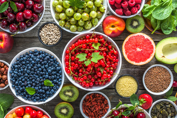 Healthy food selection. Superfoods, fresh organic fruits, assortment of berries, nuts and seeds. Detox antioxidant diet with vegetarian ingredients.