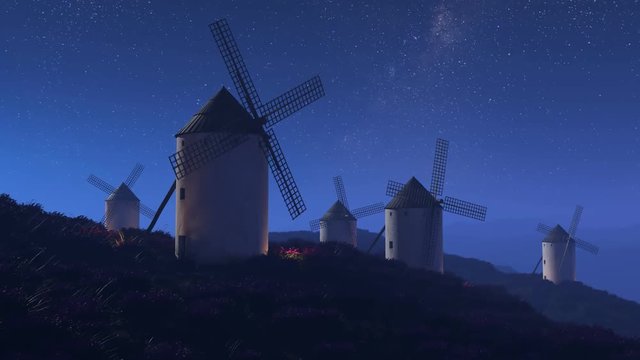 Multiple old, vintage, Spanish windmills rotating slowly at night. 4K HD