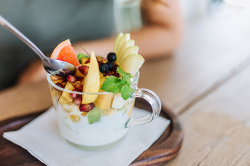 Healthy fruit salad with yogurt in glass cup.