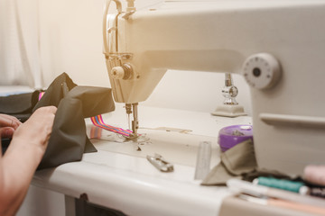 Closeup photo of female tailor working on sewing machine