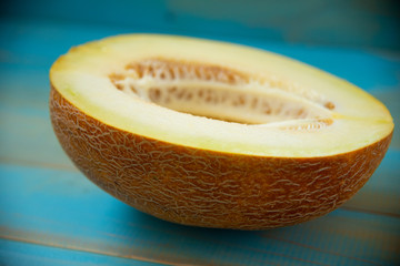 half ripe melon on a rustic, blue wooden background