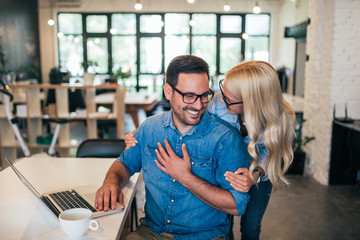 Successful smiling business couple hugging.