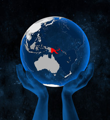 Papua New Guinea on globe in hands