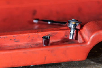 Auto repair shop tools on a creeper in a garage