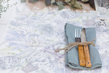 Fototapeta na wymiar Holiday Summer or early autumn outside table setting with linen napkins and green leaves. Close up