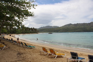 Fototapeta na wymiar Leere Liegen am Strand abgelegen und ohne Touristen am karibischen Meer.