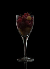 juicy berries in a glass on a black background