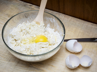 Cottage cheese, baking flour, eggs on wooden rustic table. Top view of culinary background.