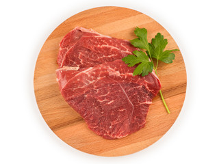 Raw meat for steak on wooden cutting board. Top view isolated with clipping path