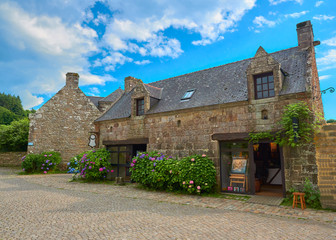 Fototapeta na wymiar Vista de unas Casas de Piedra con Jardín Típicas del Pueblo Medieval de Locronan, Finisterre, Región de Bretaña, Francia
