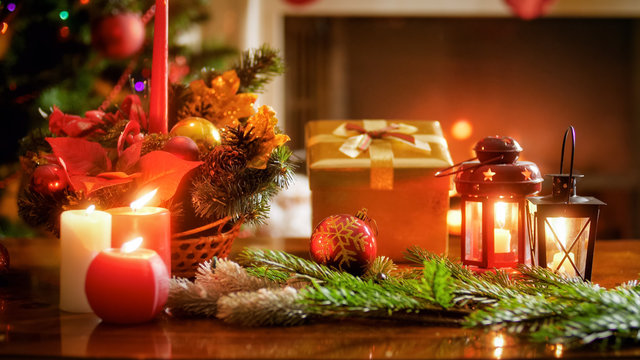 Closeup image of decorative lanterns, candles, gift ox and Christmas wreath in living room
