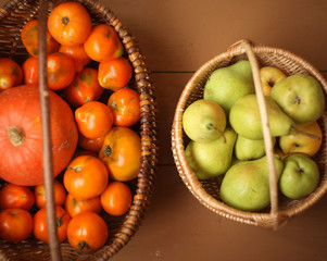 abasket with yellow tomatoes and a pumpkin  and a basket with pears /Organic Vegetables autumn harvest / healthy organic food concept background