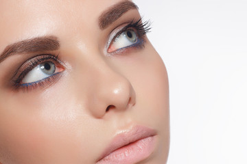 Naklejka premium Close-up of female eyes with trendy evening make-up, thick even eyebrows and long rustnitsami. Gray-blue eyes, lenses, eyesight, cosmetology, make-up