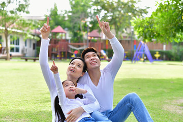 Obraz premium Family Concept. Family is doing happy activities at Playground. Parents with children are playing in the garden.