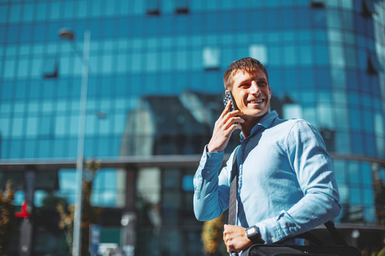 Modern businessman talking to the phone on the street