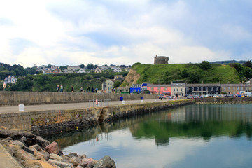 The East Pier of Howth Harbour, Dublin, Ireland with a Martello Tower in the background.
