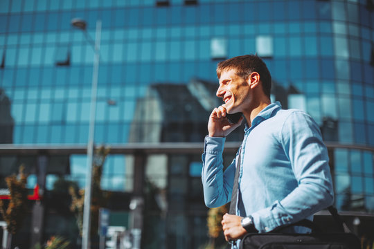 Modern businessman talking to the phone on the street