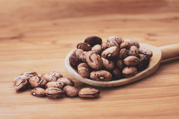 Judias Pintas crudas en fondo de madera