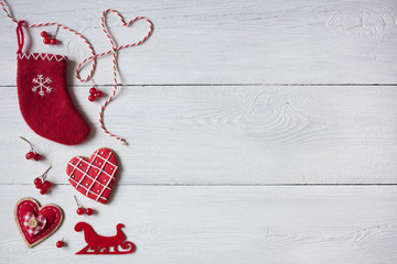 Christmas wooden white background, red sock, heart and red berries