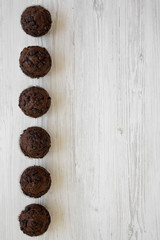 Chocolate muffins on white wooden table, top view. Flat lay, overhead, from above. Copy space.