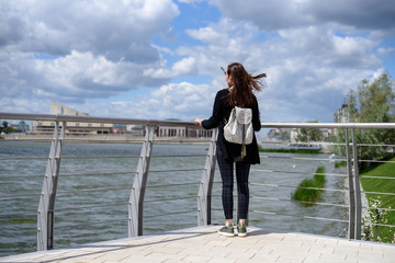 girl stands on the waterfront and looks into the distance