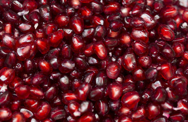 Red background of pomegranate seeds close-up